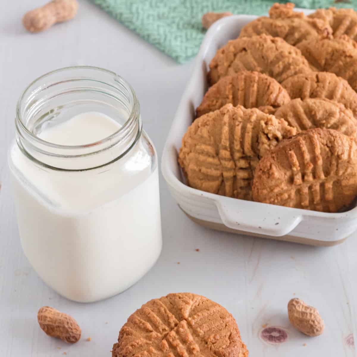 A pan full of peanut butter cookies and a glass of milk.