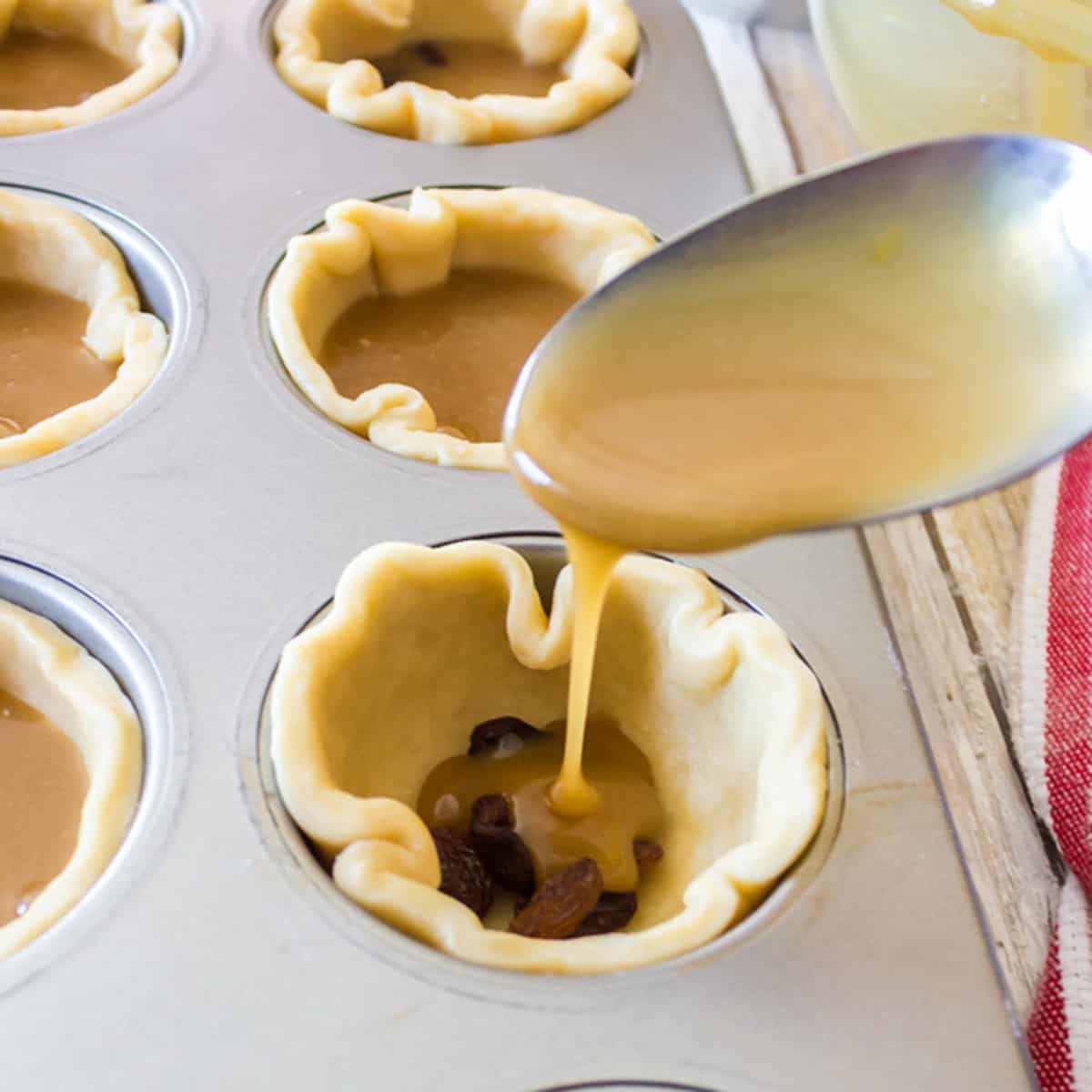 Adding filling to mini-tarts.