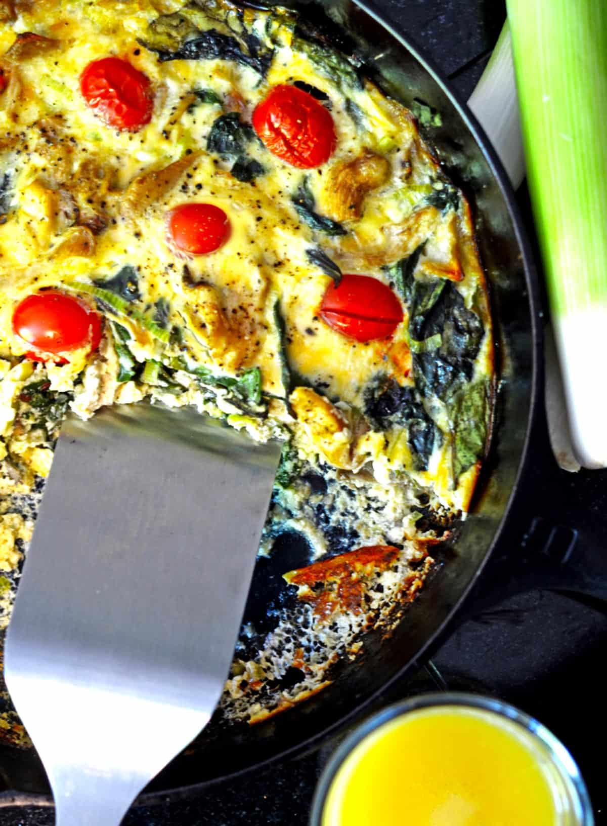 A vegetable quiche in a cast-iron skillet.