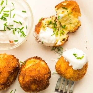 a plate of croquettes with sour cream.