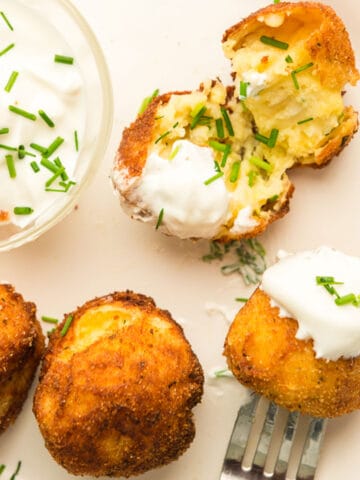 a plate of croquettes with sour cream.