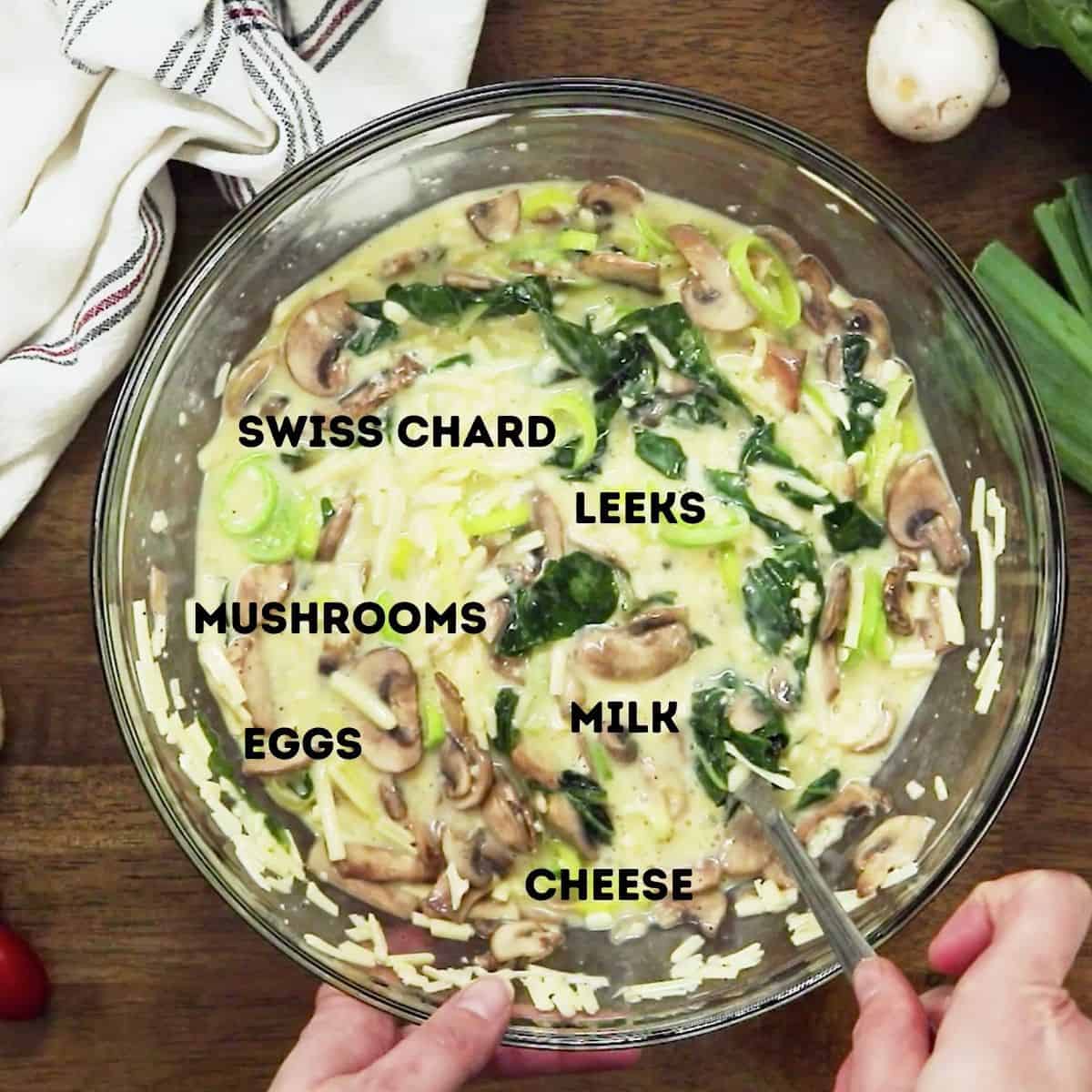 A mixing bowl of ingredients for a veggie quiche.
