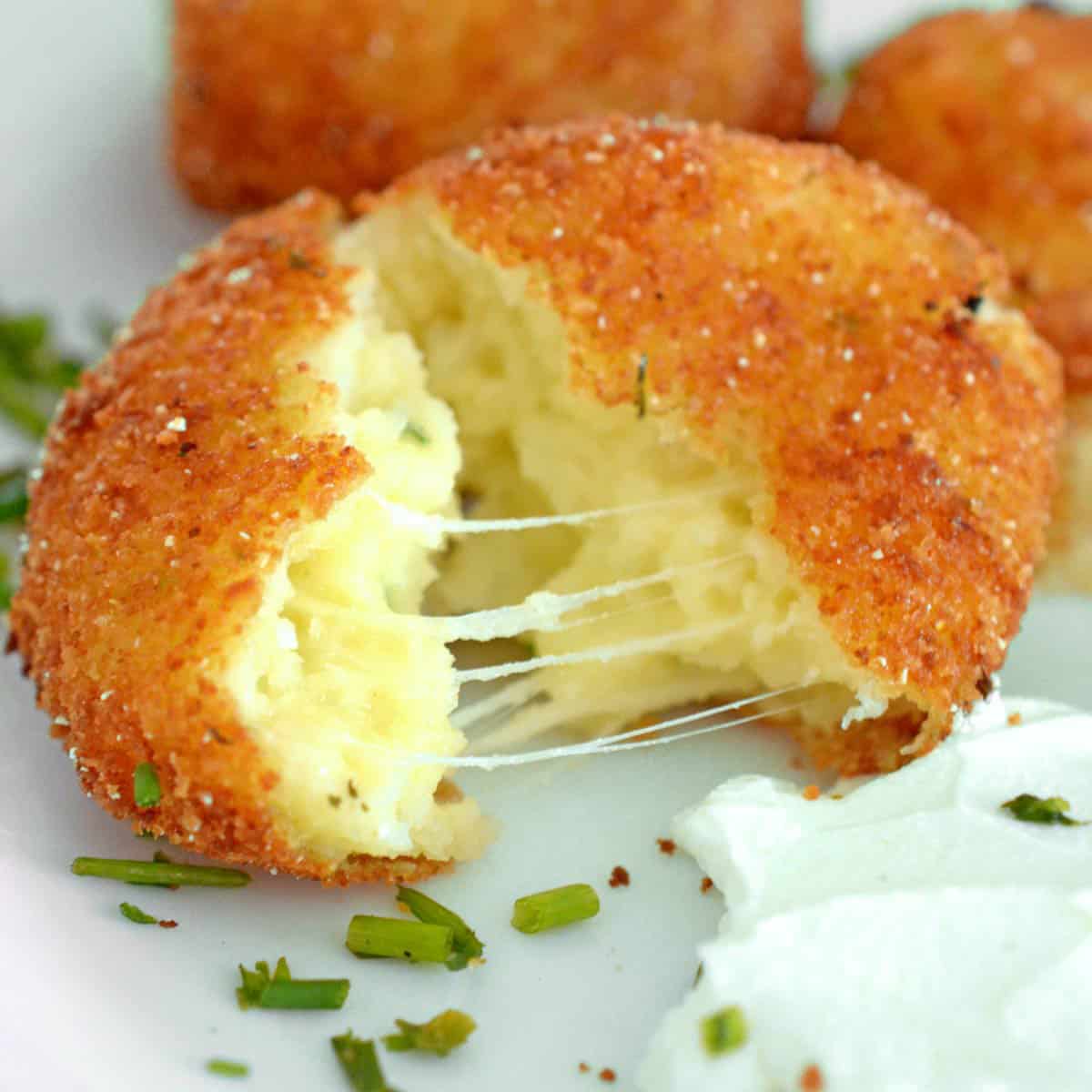 A croquette split open with stringy cheese.