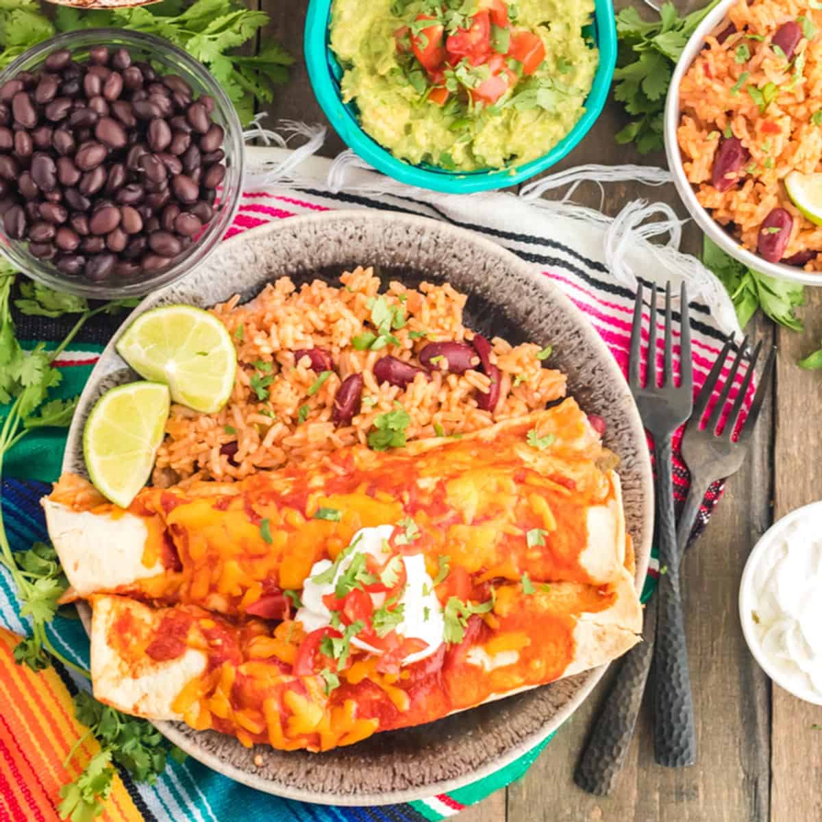 A plate of enchiladas with black beans and gaucamole.