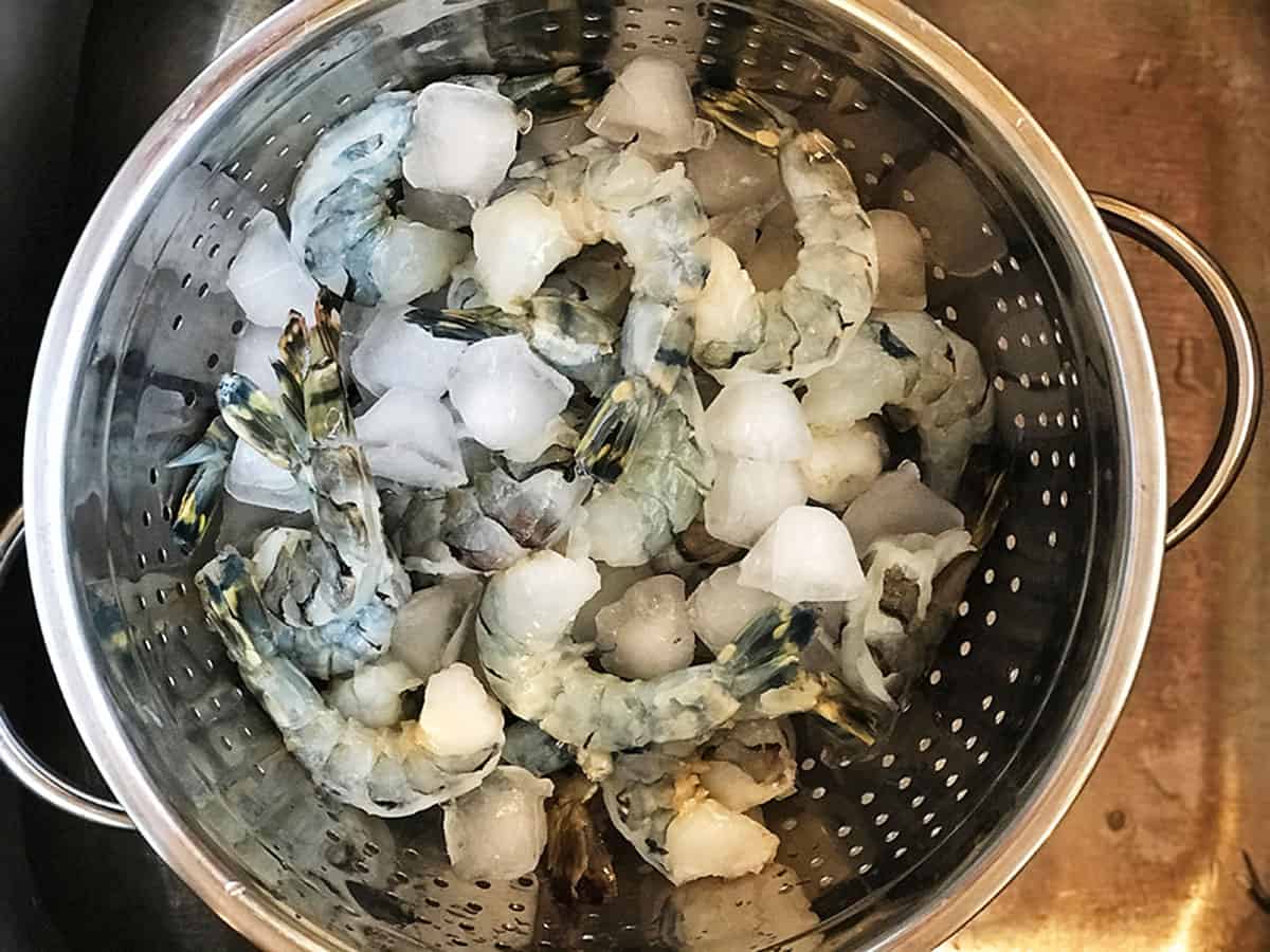 a bunch of peeled jumbo shrimp in a colender.