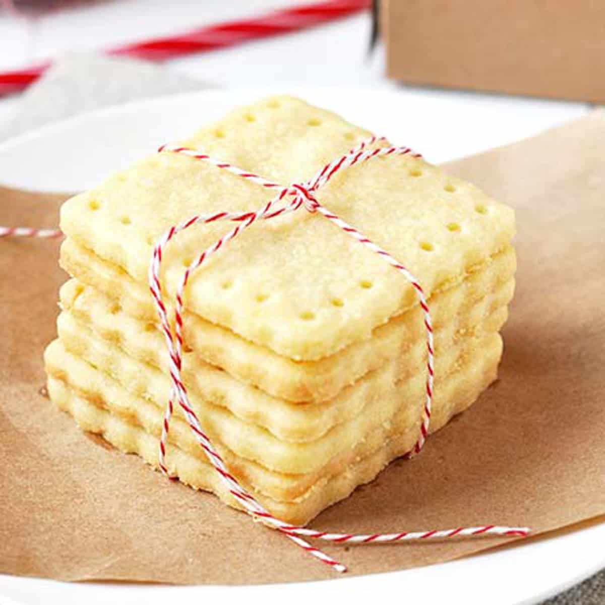 a stack of square and stamped shortbread cookies with holiday twine.
