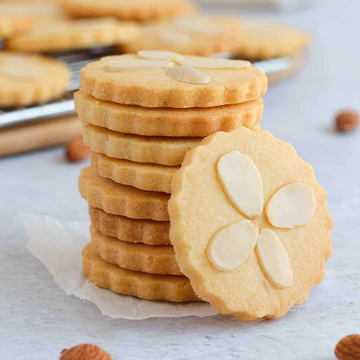 A stack of cookies with almond slivers on top.