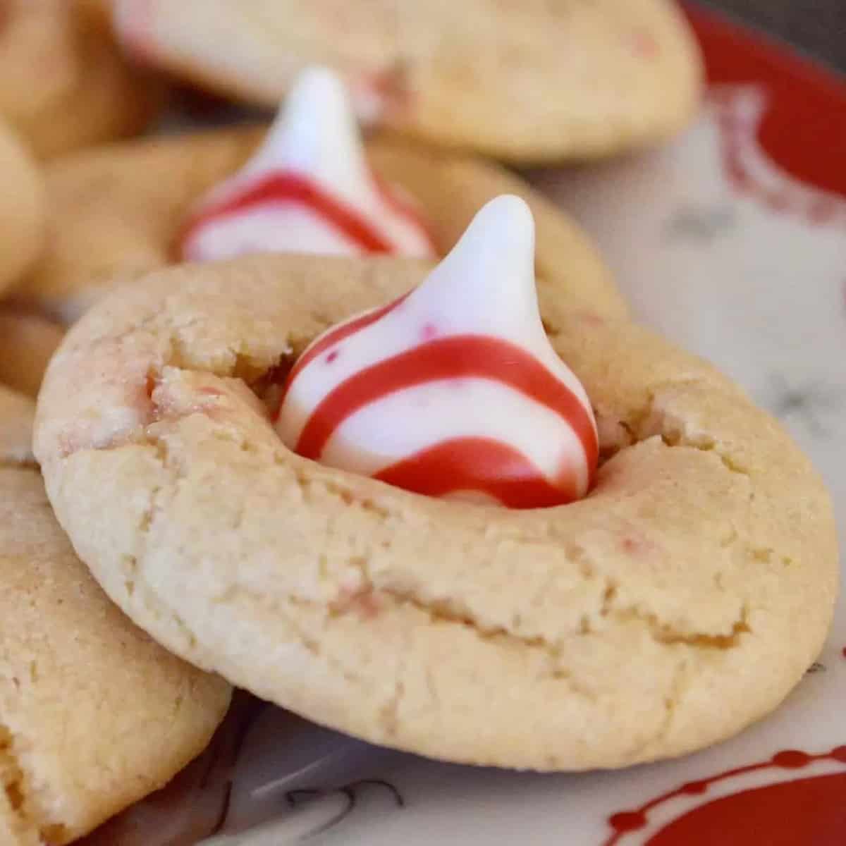 A white cookie with a candy cane kiss in the center.
