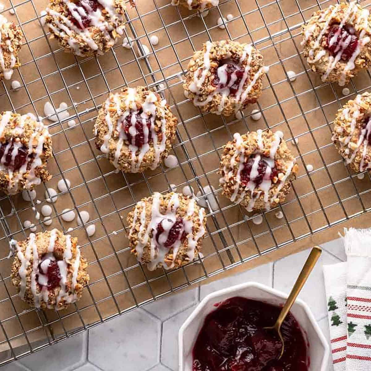 A bunch of thumbprint cookies on a cooling rack.