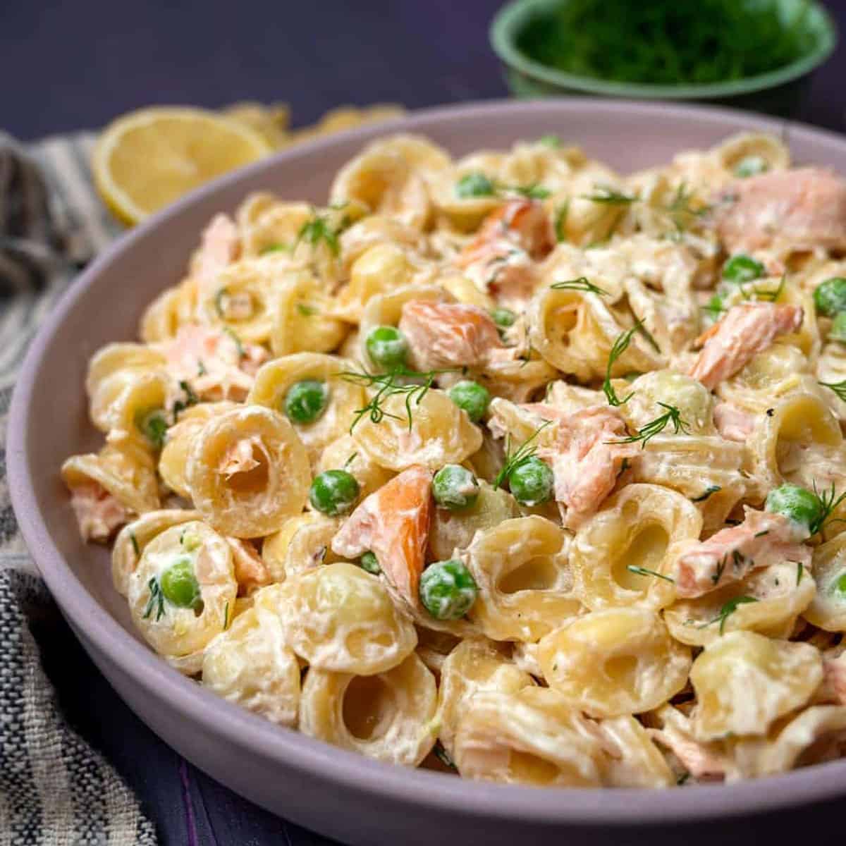 A bowl of creamy pasta with peas and smoked salmon.