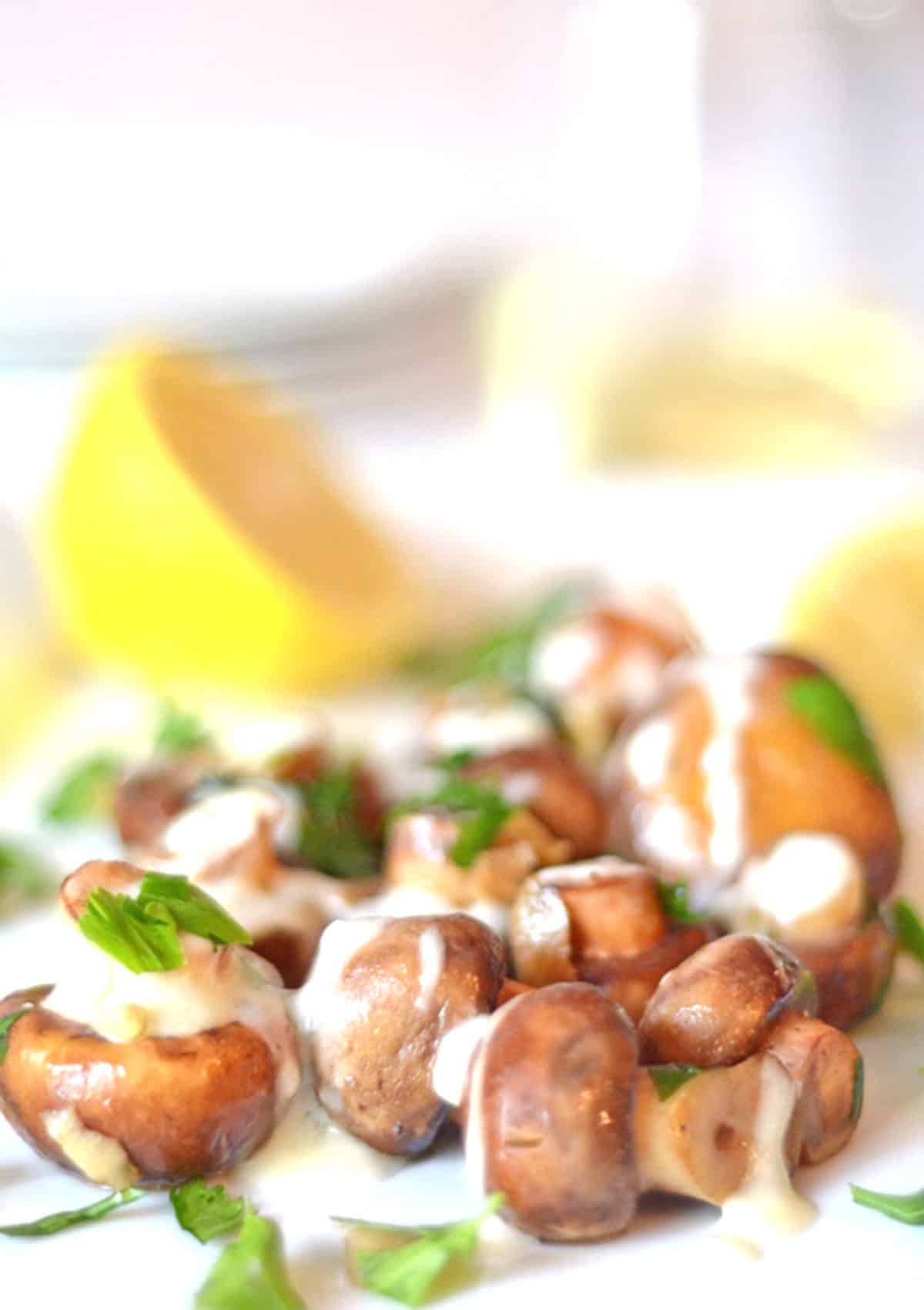 A plate of button mushrooms covered in cream.