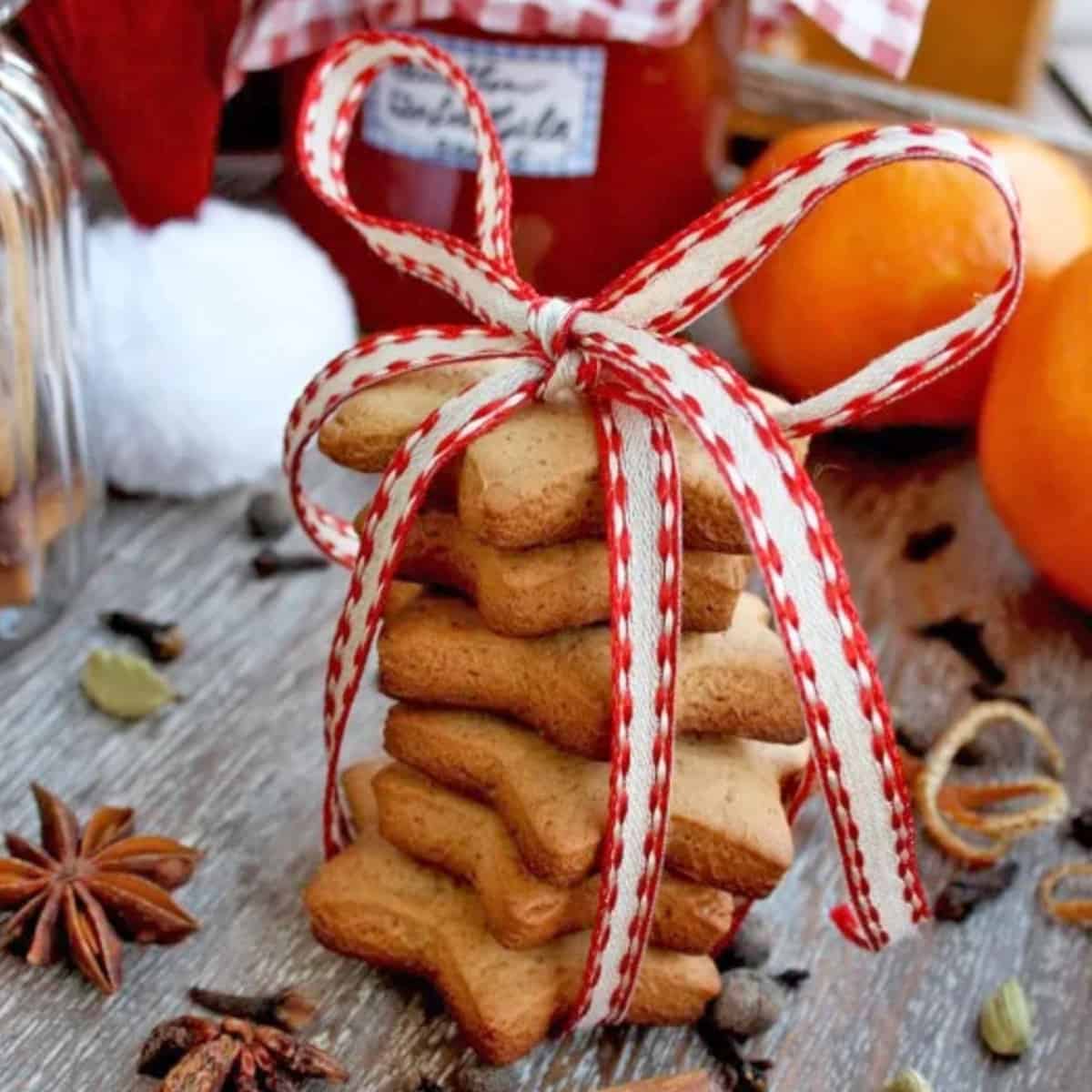 A stack of brown star-shaped cookies with holiday ribbon.