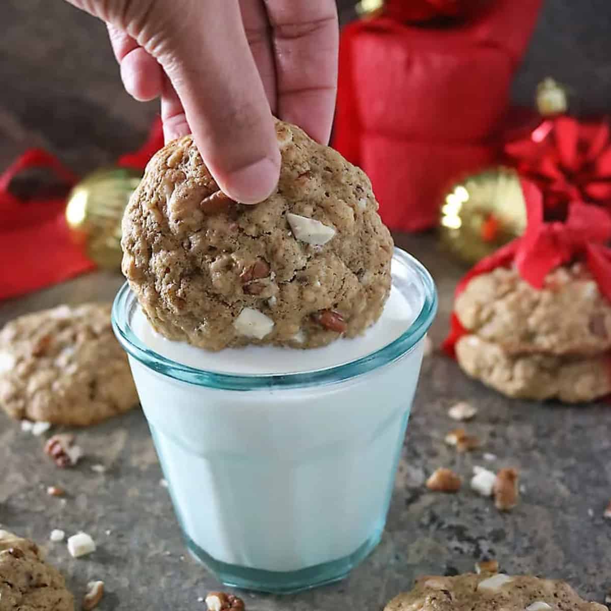 A cookie being dunked in a glass of milk.