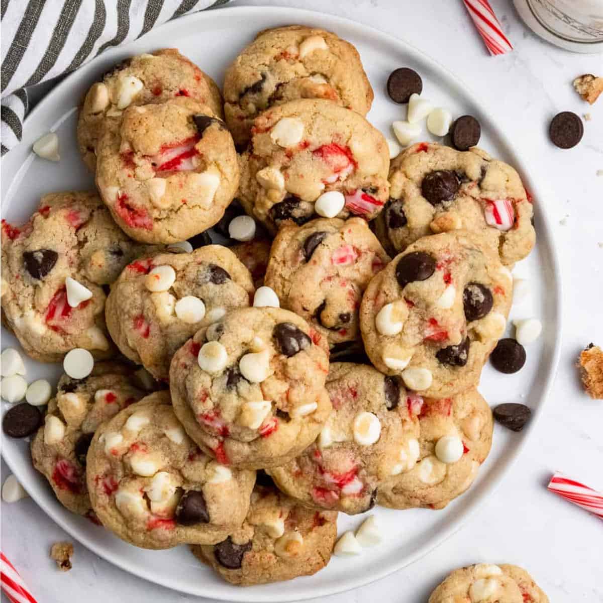 A big plate of cookies with pieces of candy canes.