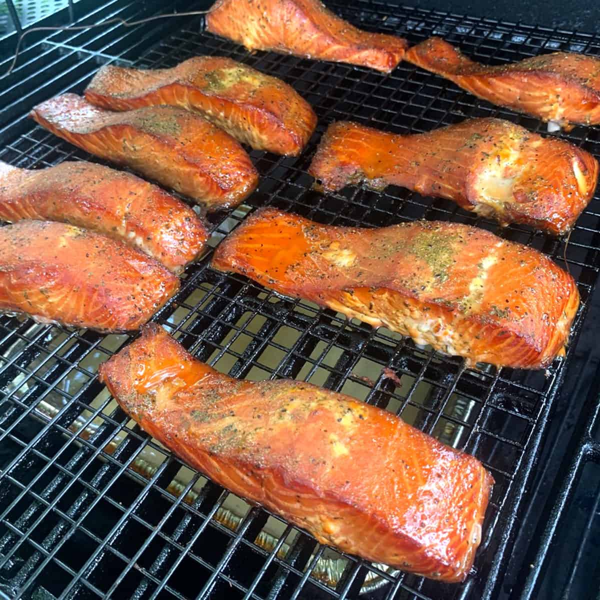 a bunch of salmon pieces on a grill.