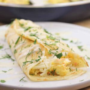 A breakfast crepe on a white plate.