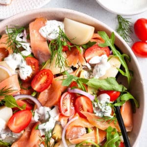 A colorful salad with smoked salmon and tomatoes.