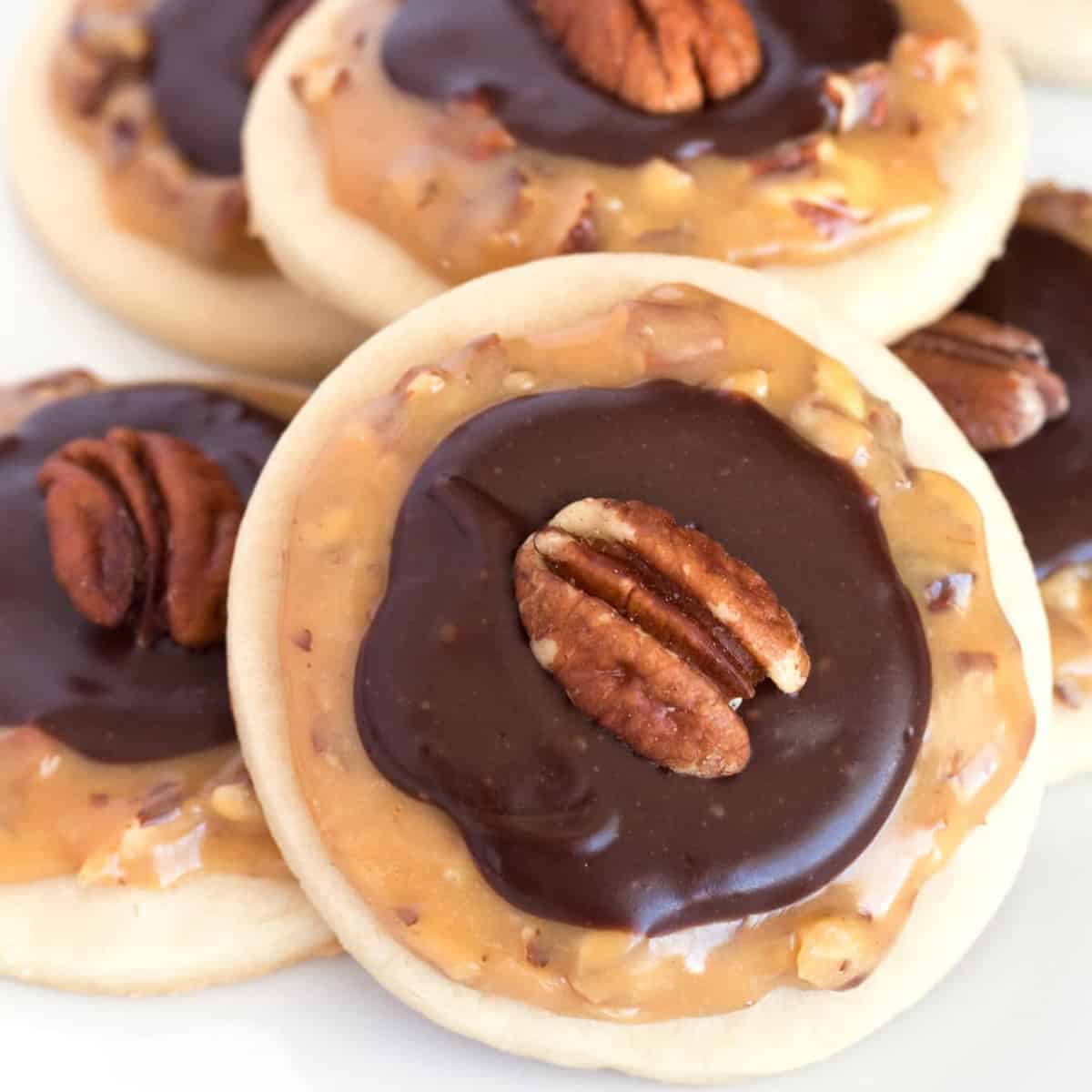 A group of round cookies with chocolate and pecans.