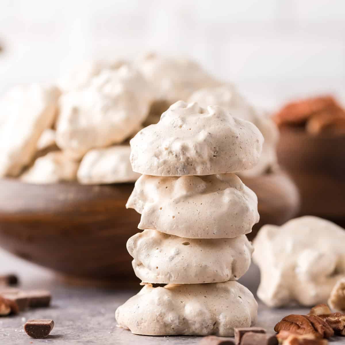 A stack of white cookies with bits of chocolate.