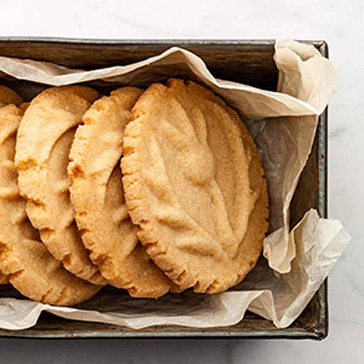 A tin of cookies with paper wrapping.