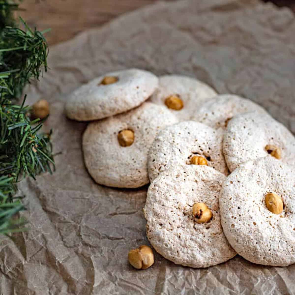 A group of round cookies with hazelnuts in the center.