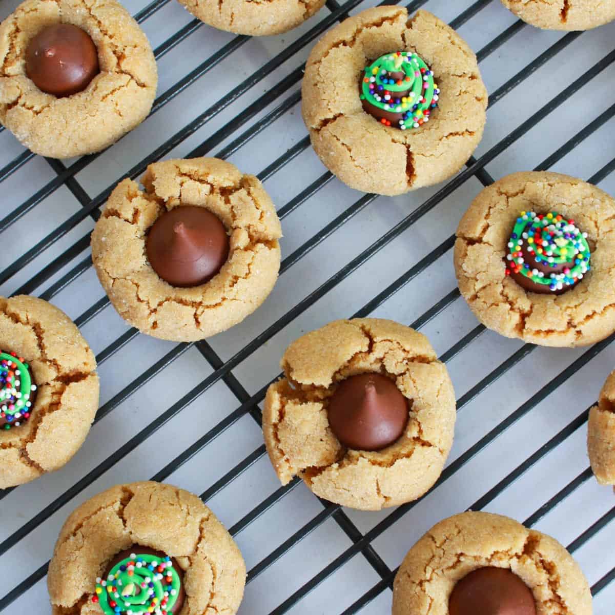 A bunch of peanut butter blossom cookies on a cooling rack.