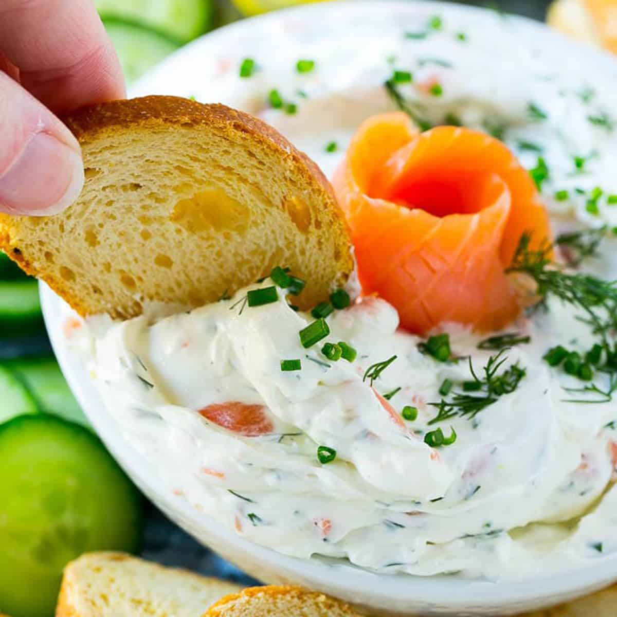 Dipping a piece of toast into a bowl of dip.