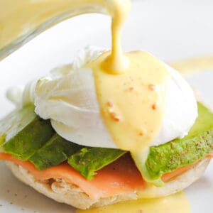 Pouring sauce over eggs Benedict