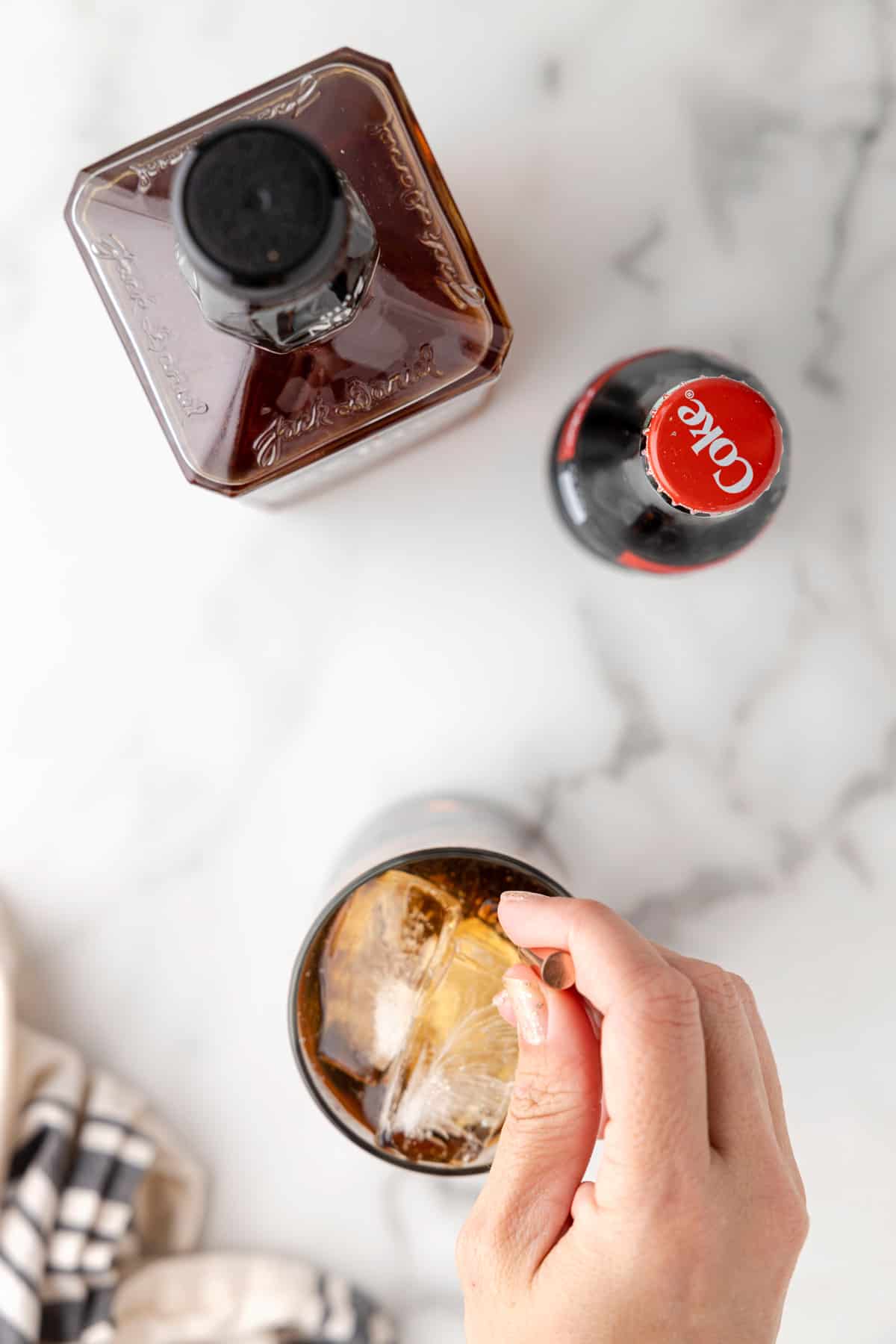 Stirring a cocktail in a highball glass with ice.