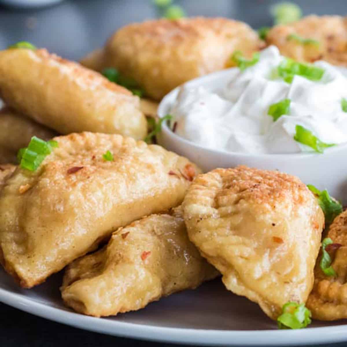 A plate of Polish dumplings and sour cream.