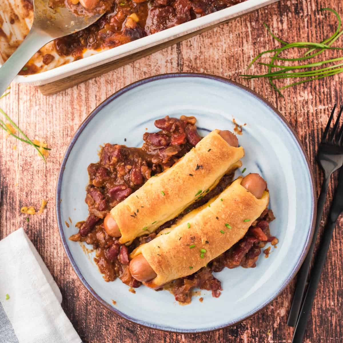 A serving of chili cheese corn dogs on a plate.