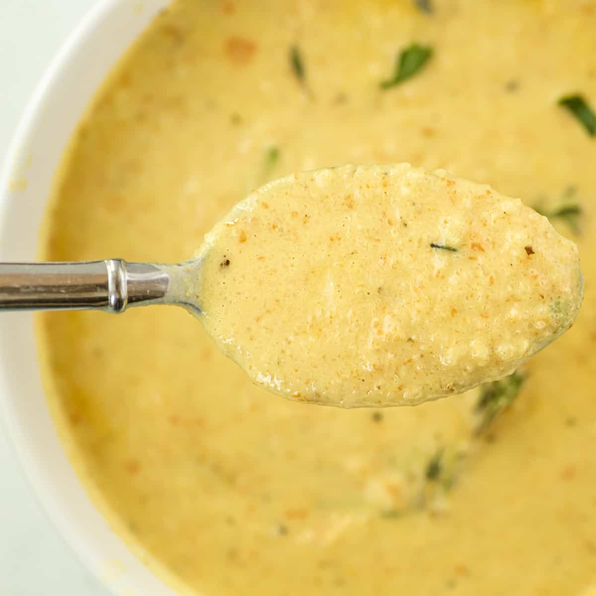 A spoonful of soup coming out of a bowl.