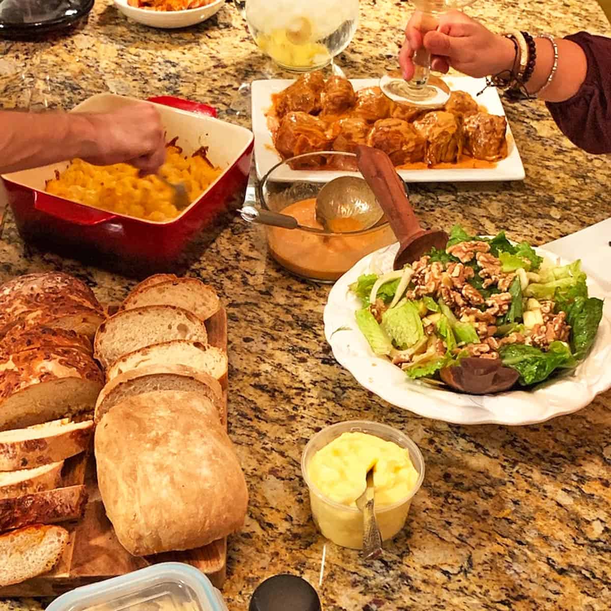 A bunch of food and leftover bread on a counter top.