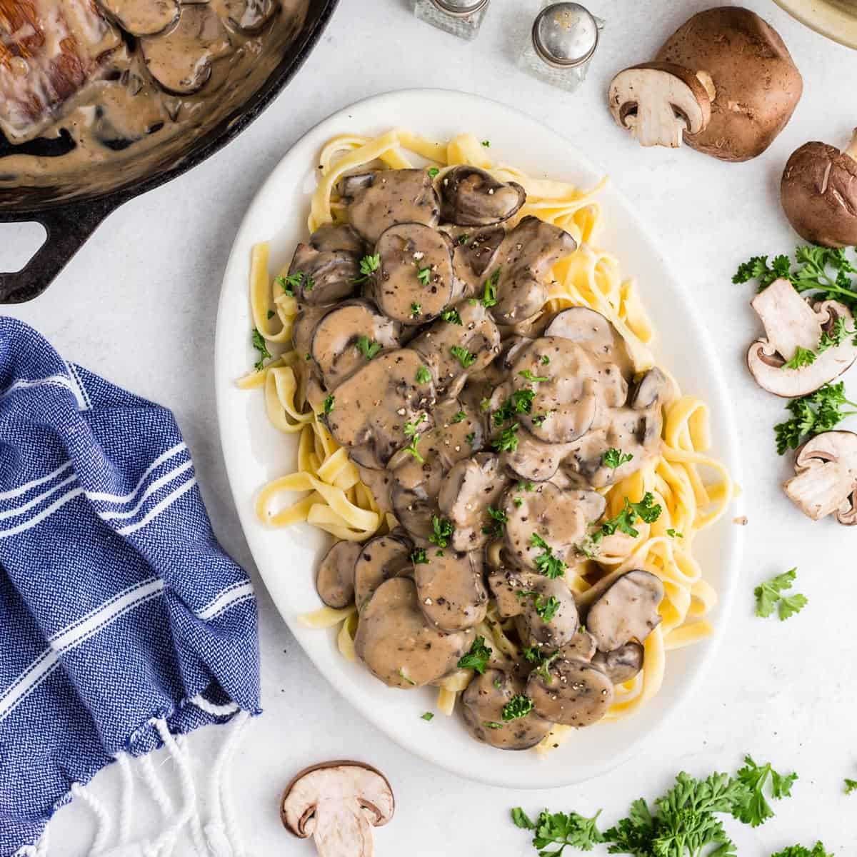 A plate of pasta covered with creamy mushroom sauce.