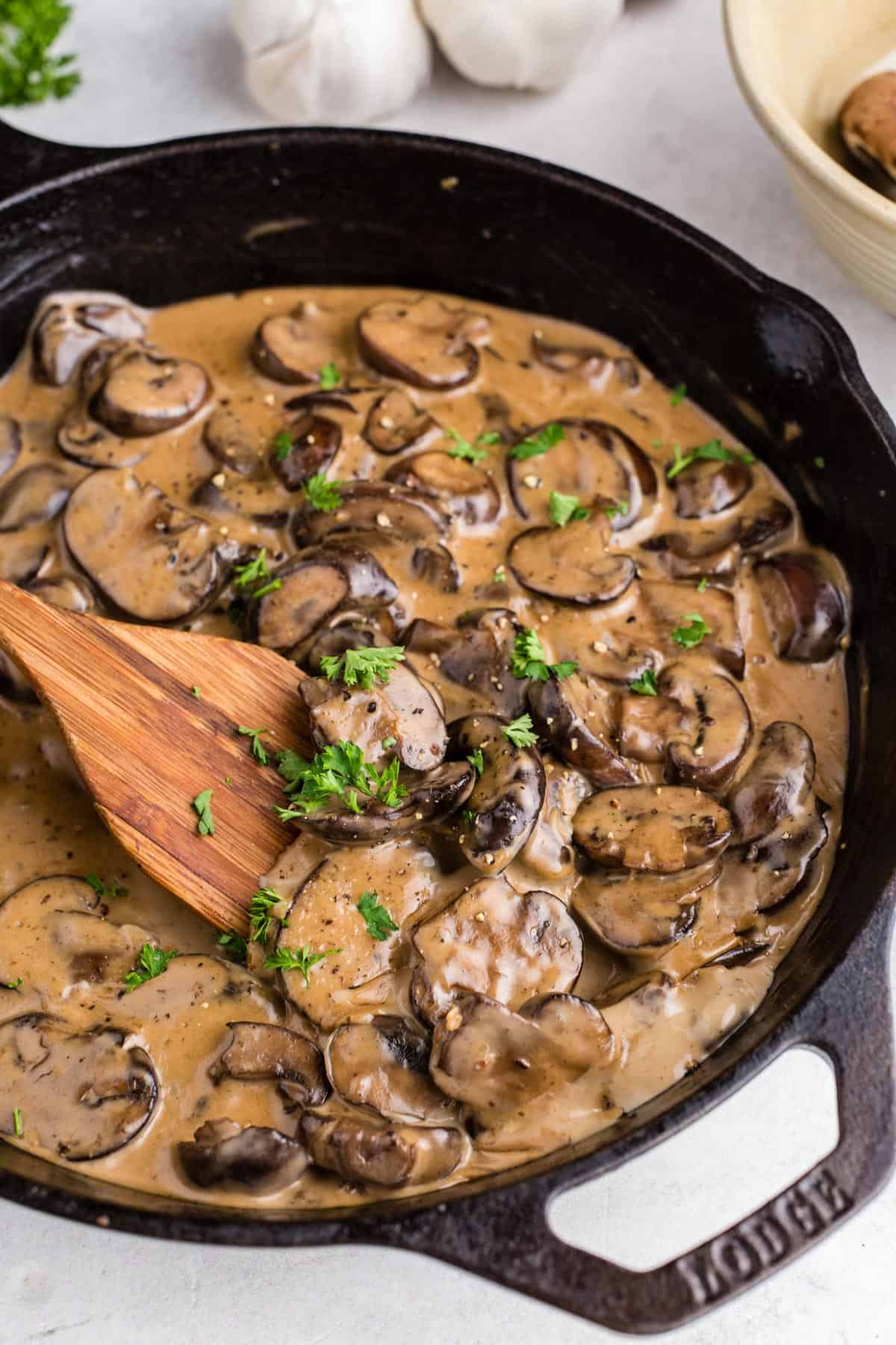 A skillet with creamy mushroom sauce and parsley.