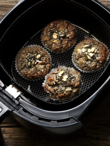 some cupcakes in an air fryer basket.