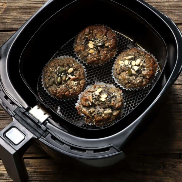 some cupcakes in an air fryer basket.