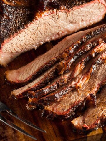 A smoked brisket sliced on a cutting board.