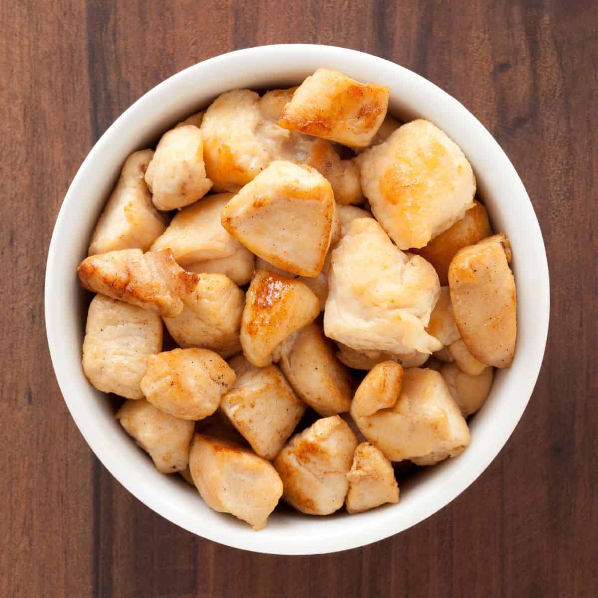 A bowl of cooked diced chicken.