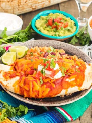 A plate of enchiladas and other Mexican food.