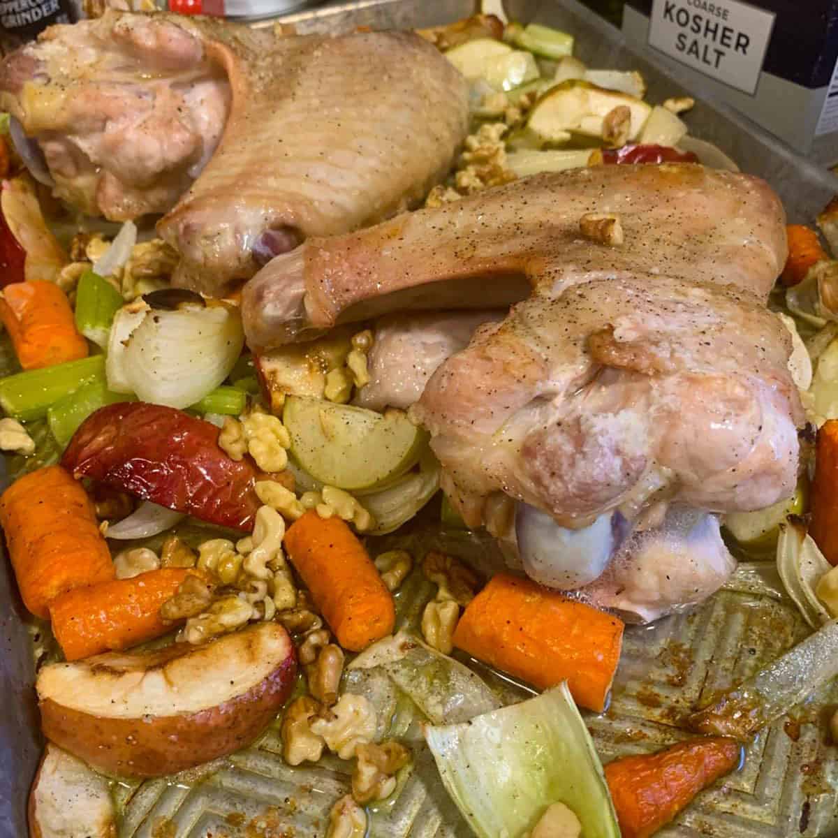 A tray of roasted turkey parts and vegetables.