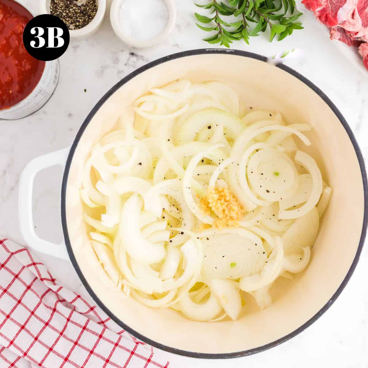 Some onions and garlic in a Dutch oven pot.