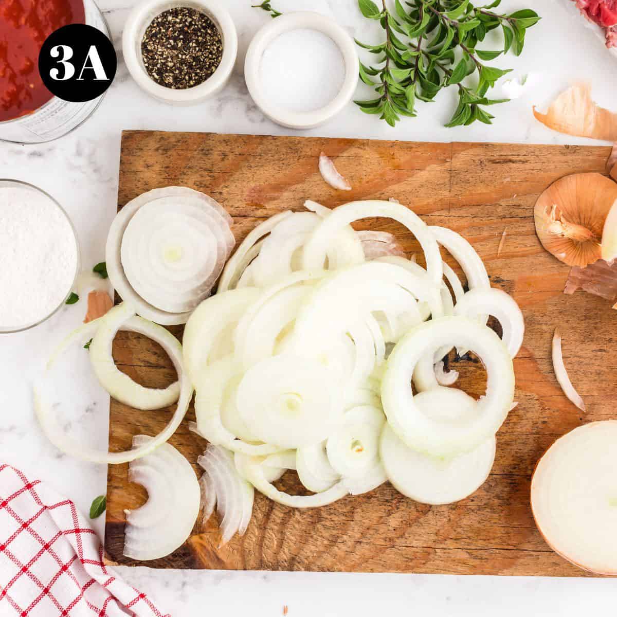 A bunch of sliced onions on a cutting board.