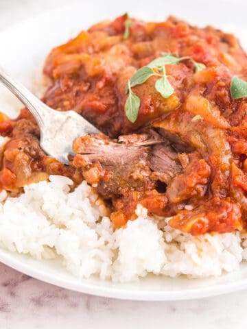 A serving of Swiss steak over white rice.