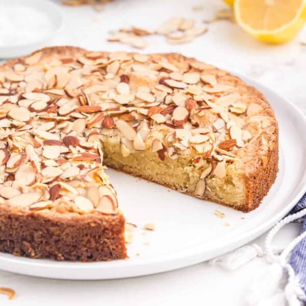 An almond cake with a slice missing.