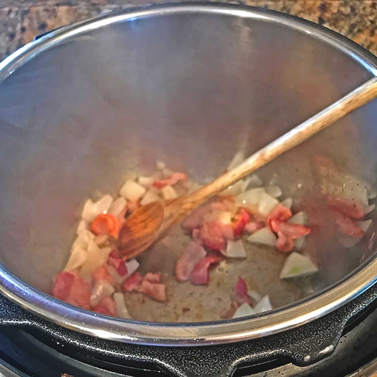 Sauteing some onions and bacon in an instant pot.