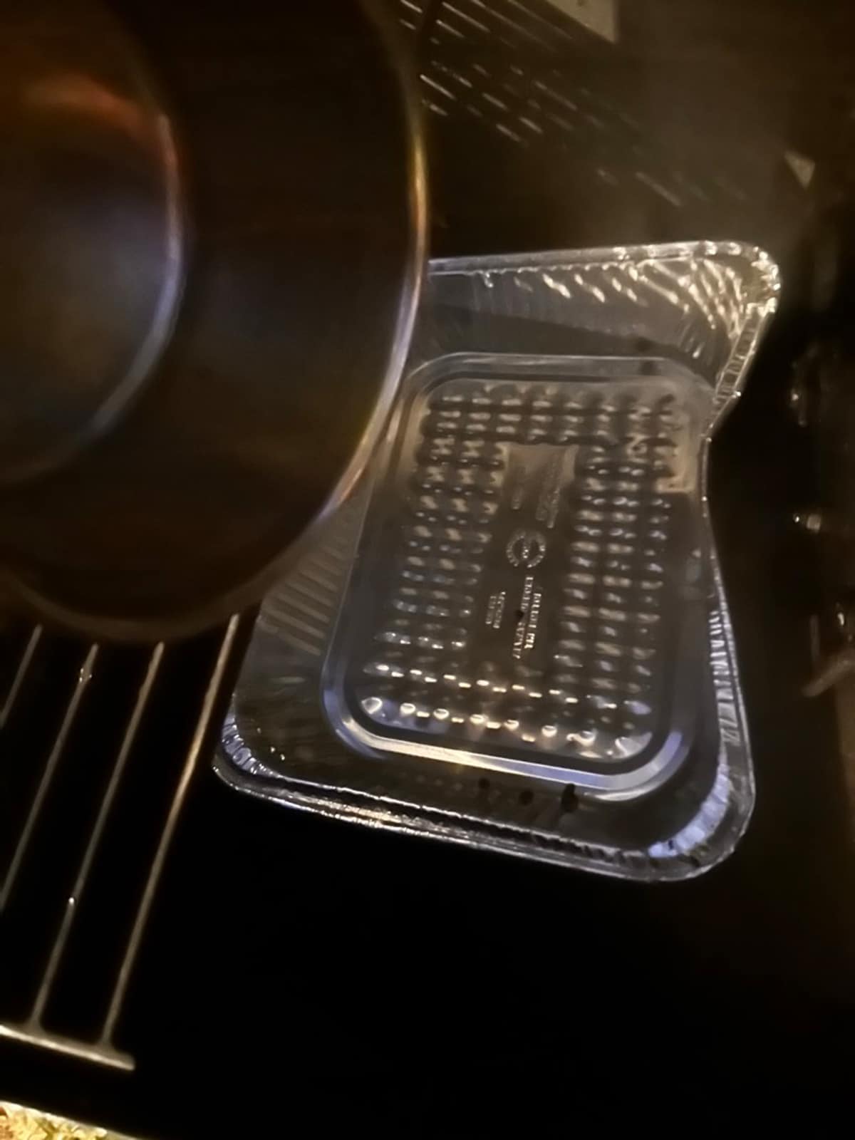 Adding water to a water pan on a smoker.