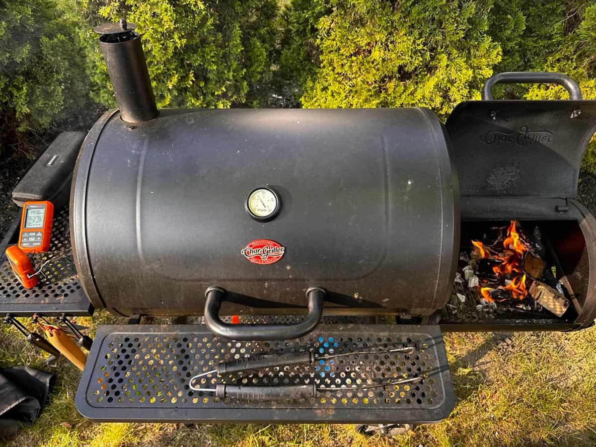 An offset smoker with a fire burning.