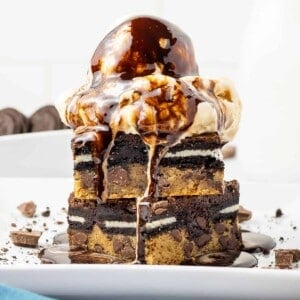 A stack of brownies with ice cream on top.