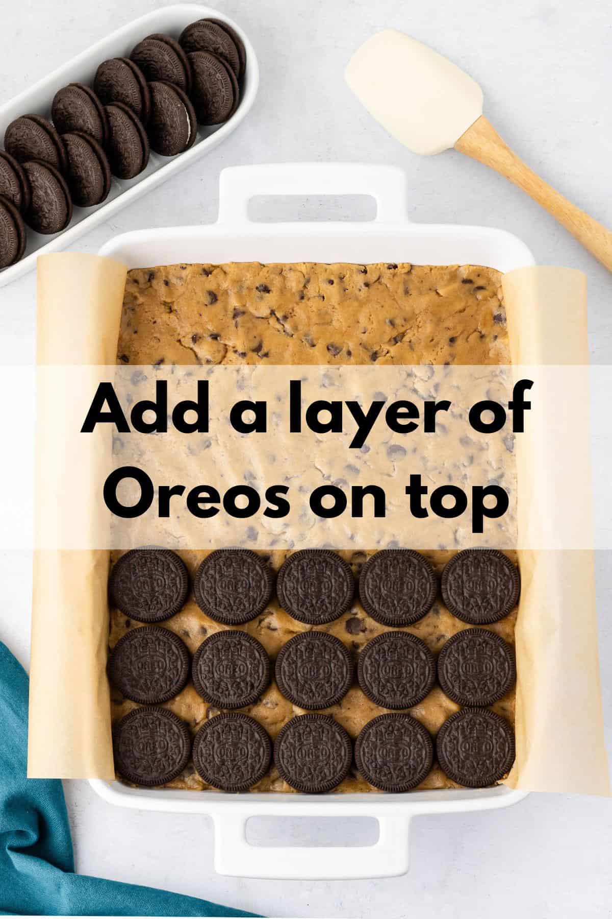 Adding a layer of brownies to a layer of cookie dough.